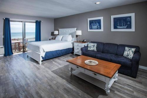 a bedroom with a bed and a couch and a table at Beachcomber Resort at Montauk in Montauk
