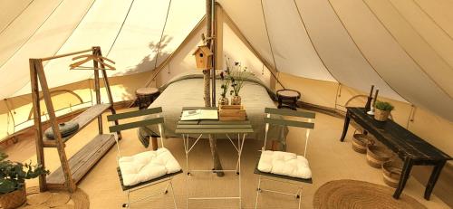 a room with a table in a tent at Petit a Petit - gypsy wagons and Bell tents in the Bourgogne in Saisy