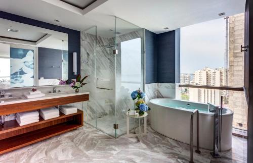 a bathroom with a tub and a glass shower at Hotel InterContinental Cartagena by IHG in Cartagena de Indias