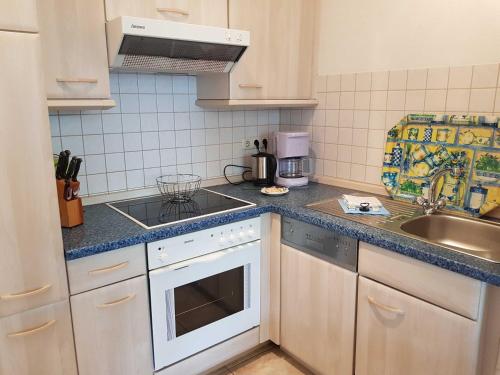 a kitchen with a sink and a stove top oven at Residenz Seeblick Whg 4, mit Gartenzugang in Ostseebad Sellin