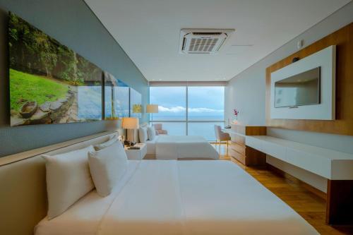 a hotel room with two beds and a television at Hotel InterContinental Cartagena by IHG in Cartagena de Indias