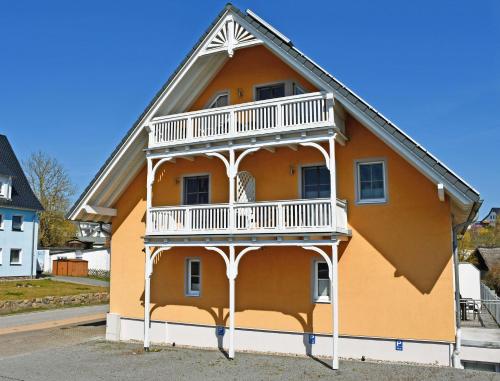 a house with a balcony on the side of it at Hotel Sonnenklahr mit Pool in Göhren