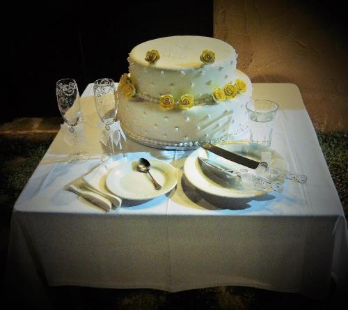 a table with a wedding cake and plates on it at Guesthouse Amanitis Caesarea in Skíti