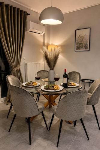 a dining room table with plates of food and wine at Allure villa in Porto Rafti