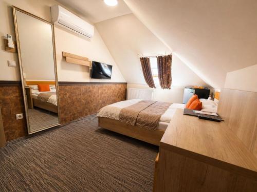 a hotel room with a bed and a large mirror at Hotel Dolce Vita in Balatonkenese