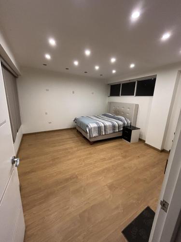 a bedroom with a bed and a wooden floor at Luxury apartment with park views in Huancavelica