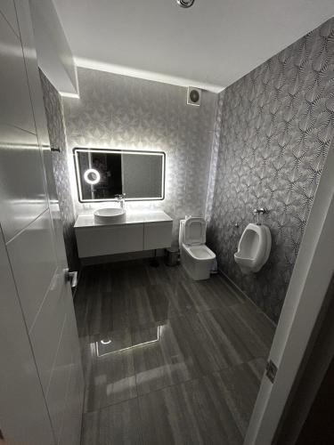 a bathroom with two toilets and a sink and a urinal at Luxury apartment with park views in Huancavelica