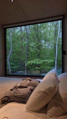 a bed in a bedroom with a large window at Dvoye in Vodniki