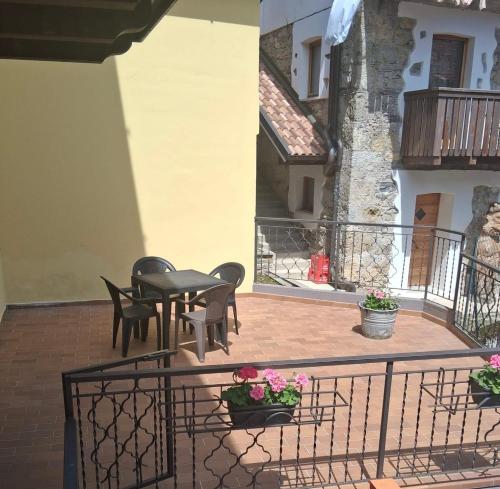 a patio with a table and chairs on a balcony at Appartamento della Nonna in Sùtrio
