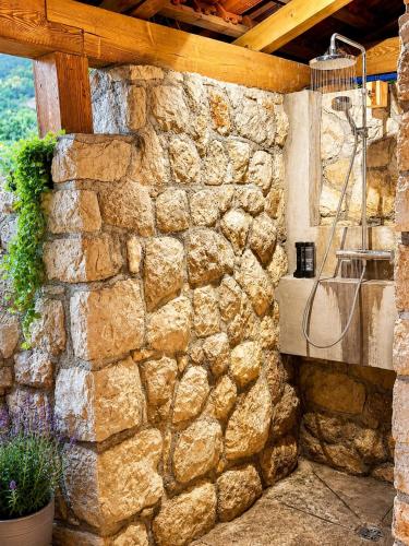 a stone wall with a sink in a building at Pljesa Apartments -Meerblick mit Terrasse & Grill by rentyourhome24 in Supetarska Draga