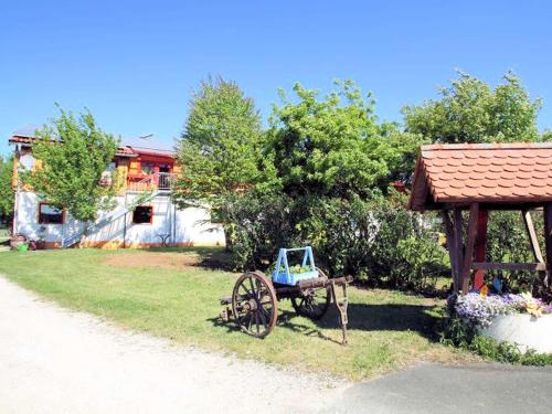 a wooden cart sitting in the grass next to a house at Ferienhof Gold in Waischenfeld
