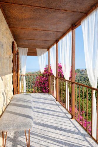 a balcony with white curtains and a view at Boreas Retreat - Mountain Escape & Spa in Batroûn