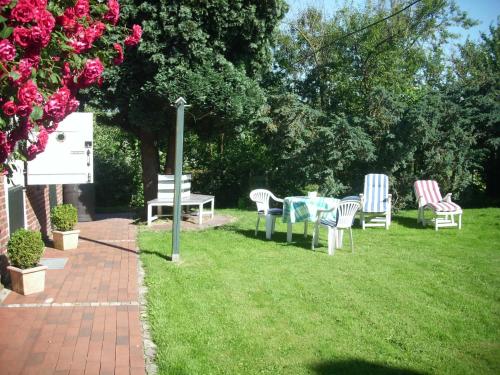 a group of chairs and tables in the grass at Ahlborns Bluetenhof in Jork