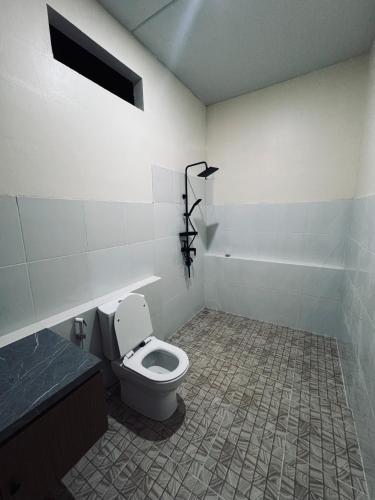 a bathroom with a toilet and a bath tub at Bale Bangket Homestay in Tetebatu