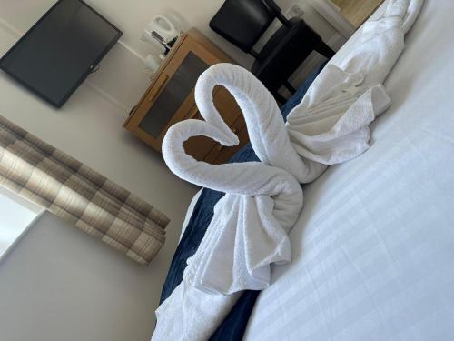 two swans wrapped in towels sitting on a bed at Morecambe Rooms in Morecambe