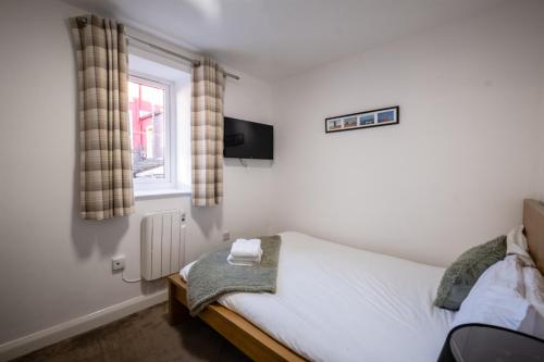 a small bedroom with a bed and a window at Morecambe Rooms in Morecambe