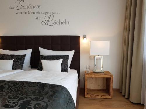 a bedroom with a bed and a table with a lamp at Hubertushof in Jungholz