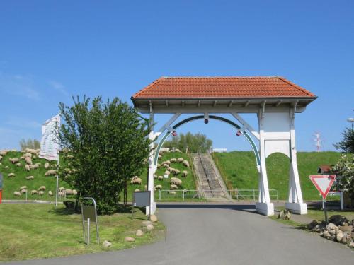 a gazebo with a herd of sheep in a field at Ferienhaus Deichgraf 65 im Feriend in Hollern-Twielenfleth