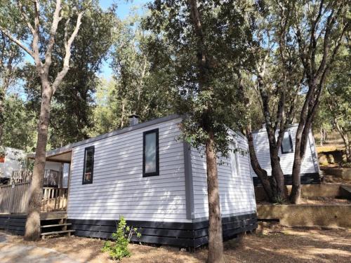 a tiny house in the middle of some trees at Camping 4 étoiles - Piscine - ccbfiee in Olmeto