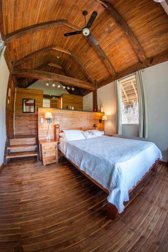 a bedroom with a large bed with a wooden ceiling at Eco Venao Lodge, Playa Venao in Playa Venao