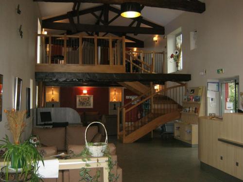 a living room with a spiral staircase in a house at Résidence Goélia Aquaresort in Nérac