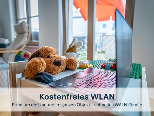 two teddy bears sitting on a table next to a laptop at Haus Klipper - Nordseebad Burhave in Burhave