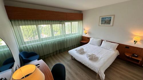 a hotel room with a bed and a table and chairs at Hotel Cristallo in Udine