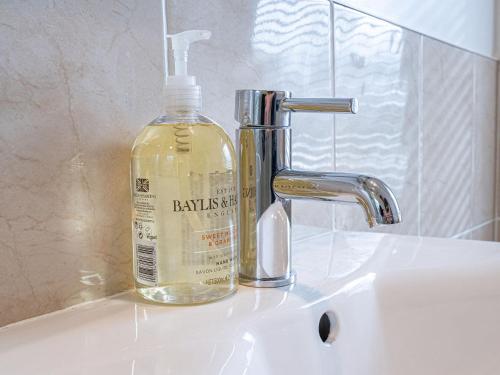 a bottle of soap sitting on a bathroom sink at Edengrove in Aberfeldy