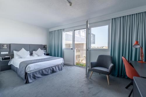 a hotel room with a bed and a chair at Holiday Inn Calais - Centre Car Ferry by IHG in Calais
