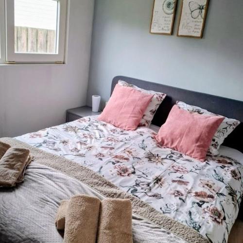 a bed with pink pillows in a bedroom at CHALET36 in GROU in Grou