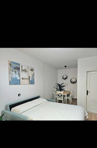 a white bedroom with a bed and a table at Casa Gelín Azul in Santillana del Mar