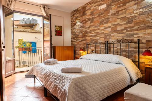 a bedroom with a large bed and a stone wall at Bed and Breakfast San Domenico in Realmonte