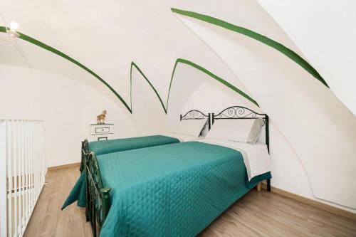 a bedroom with a green bed in a white room at Matinè Suite And Room in Matino