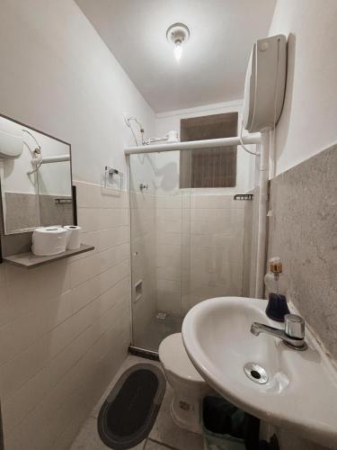 a white bathroom with a sink and a toilet at Apartamento Rua Teresa in Petrópolis