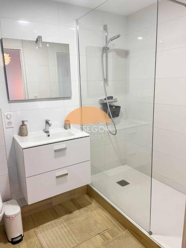 a white bathroom with a shower and a sink at Appt Ortolans - Hossegor centre - Terrasse - Park in Hossegor