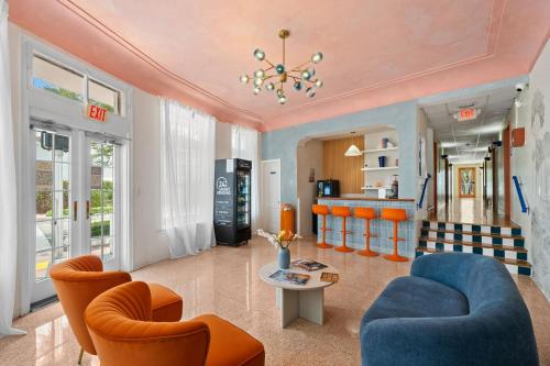 a living room with orange chairs and a blue couch at Blue Flamingo Suites in Miami Beach