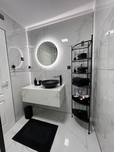 a white bathroom with a sink and a mirror at Lux Apartman Inđija in Inđija