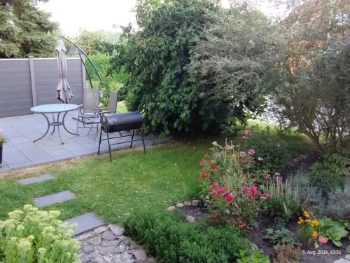 a garden with a table and chairs and flowers at Peene Alte Schule Völschow Dornberger in Völschow