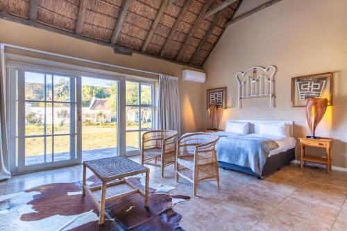 a bedroom with a bed and a table and chairs at Karoo 1 Hotel Village in De Doorns