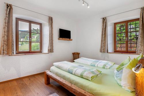 a bedroom with two beds and two windows at Schloss Gravetsch in Villandro