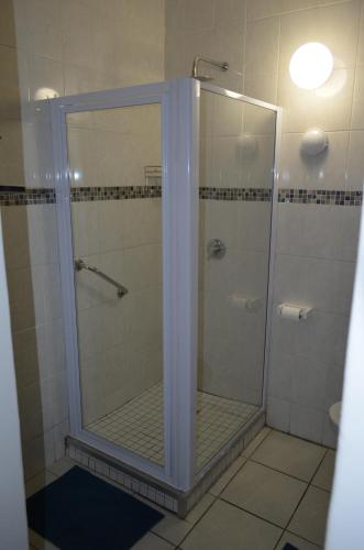a shower with a glass door in a bathroom at 3 Eden Sands in Kingsborough