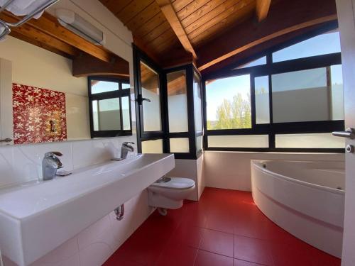 a bathroom with two sinks and a tub and a toilet at RoomRural Hotel Iru-Bide Lumbier in Lumbier