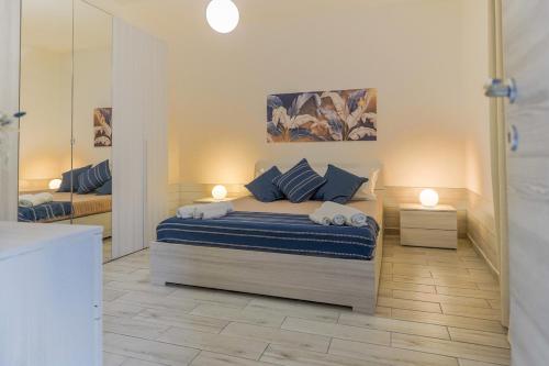 a bedroom with a bed with two lamps and a mirror at Italia Apartment in Catania