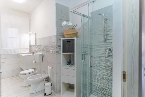 a bathroom with a toilet and a glass shower at Italia Apartment in Catania
