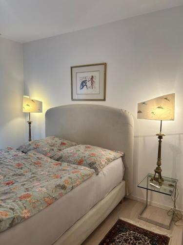 a bedroom with a bed with two lamps on it at Wohnen am St Johanner Markt in Saarbrücken