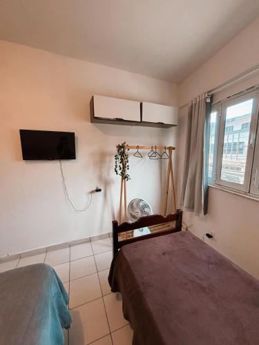 a bedroom with a bed and a tv on the wall at Apartamento Rua Teresa in Petrópolis