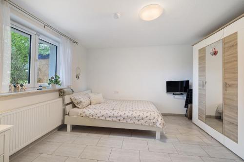 a bedroom with a bed and a sink and a window at Gemütliche Einliegerwohnung in Gomadingen
