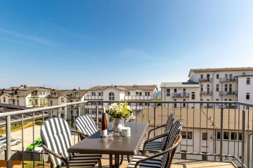 a table with chairs and flowers on a balcony at Villa Linquenda App 6 in Ahlbeck
