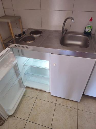 a kitchen with a sink and an open refrigerator at ΕΥΡΙΠΟΣ in Kritharia