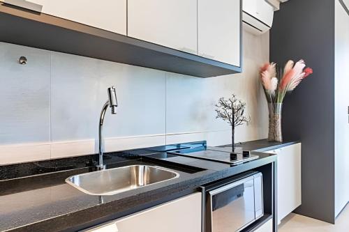 a kitchen with a sink and white cabinets at BHS Flat a beira mar 2203 in Recife
